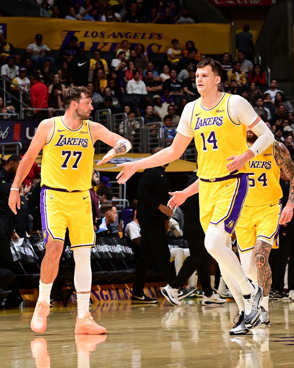Luka Doncic (77) and Walker Kessler (14) of the Los Angeles Lakers high-five during a game against the Denver Nuggets on Friday, Oct. 16, 2026, at Crypto.com Arena in Los Angeles.