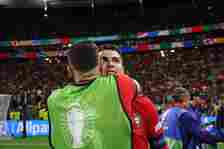 Cristiano Ronaldo of Portugal is embraced by teammate Diogo Dalot at full-time following the team's victory in the penalty-shoot-out and progressio...