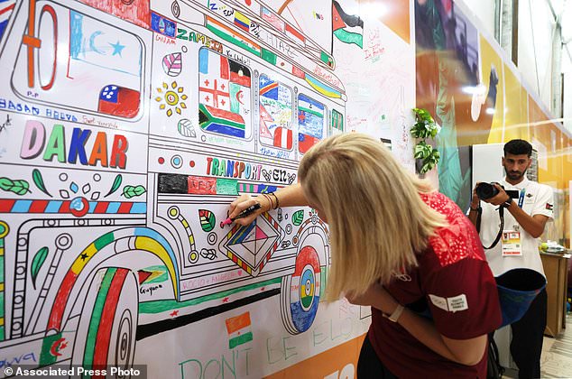 International Olympic Committee President Kirsty Coventry draws on the wall as she visits the Youth Olympic Village in Diamniadio, Senegal, Oct. 29, 2026. (Misper Apawu/Pool Photo via AP)