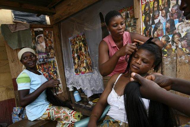A hairdresser at a local salon busies herself with a client. - [Citi FM]