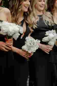 Close Up of Bridesmaids In Black Dresses Holding White Bouquets