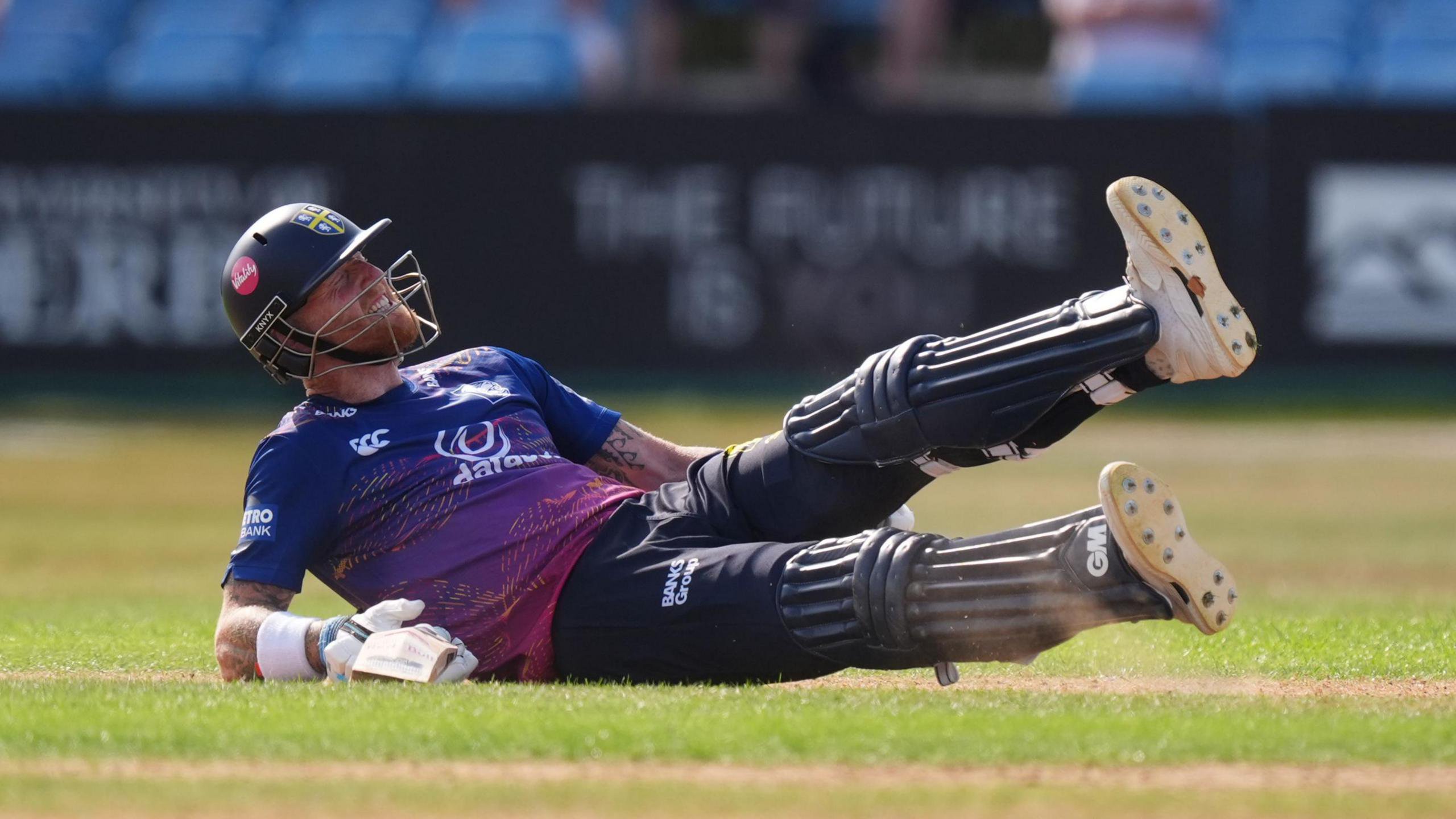 Ben Stokes is on the ground clutching the back of his left leg in pain during his innings for Durham. 