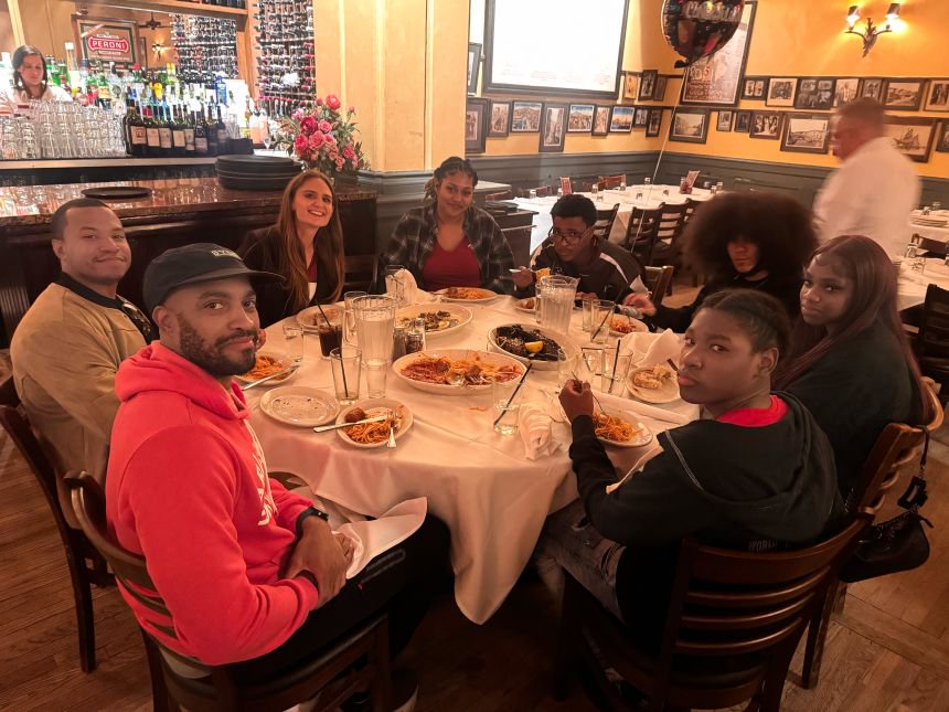 (Clockwise from front left) Harlem Run's Taurean Wiggins and Jesse Liriano, Next PAGE founder Emily Palmer, Seraine Small (Ferguson's girlfriend), Dwayne Ferguson, NP graduate Angel Soriano, student Kaniya and NP graduate Ian Adamson carbo-load at a group dinner.
