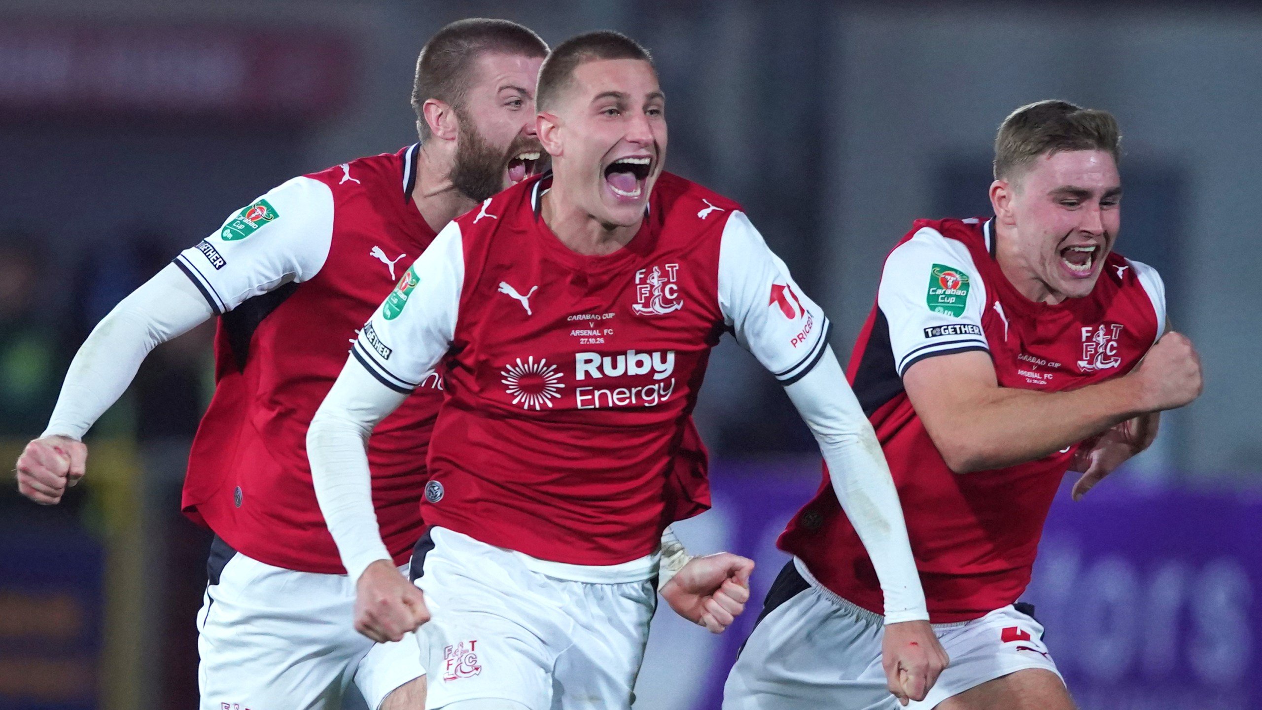 Fleetwood's players celebrate after winning a penalty shootout during the English League Cup soccer match between Fleetwood Town and Arsenal in Fleetwood, England, Tuesday, Oct. 27, 2026. (AP Photo/Ian Hodgson)