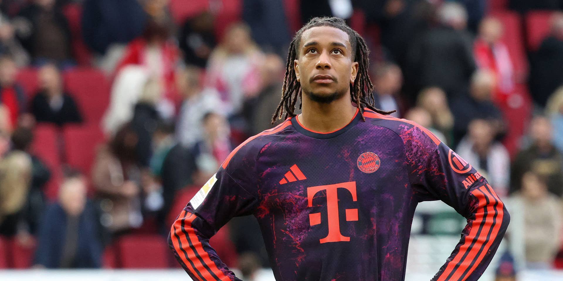 Ein Bayern-Spieler steht nach einem Fußballspiel nachdenklich mit den Händen in der Hüfte auf dem Feld.