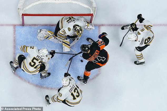 Philadelphia Flyers' Sean Couturier (14) battles for the puck against Boston Bruins' Linus Ullmark (35), Andrew Peeke (52), Charlie Coyle (13) and Mason Lohrei (6) during the second period of an NHL hockey game, Saturday, March 23, 2024, in Philadelphia. (AP Photo/Matt Slocum)