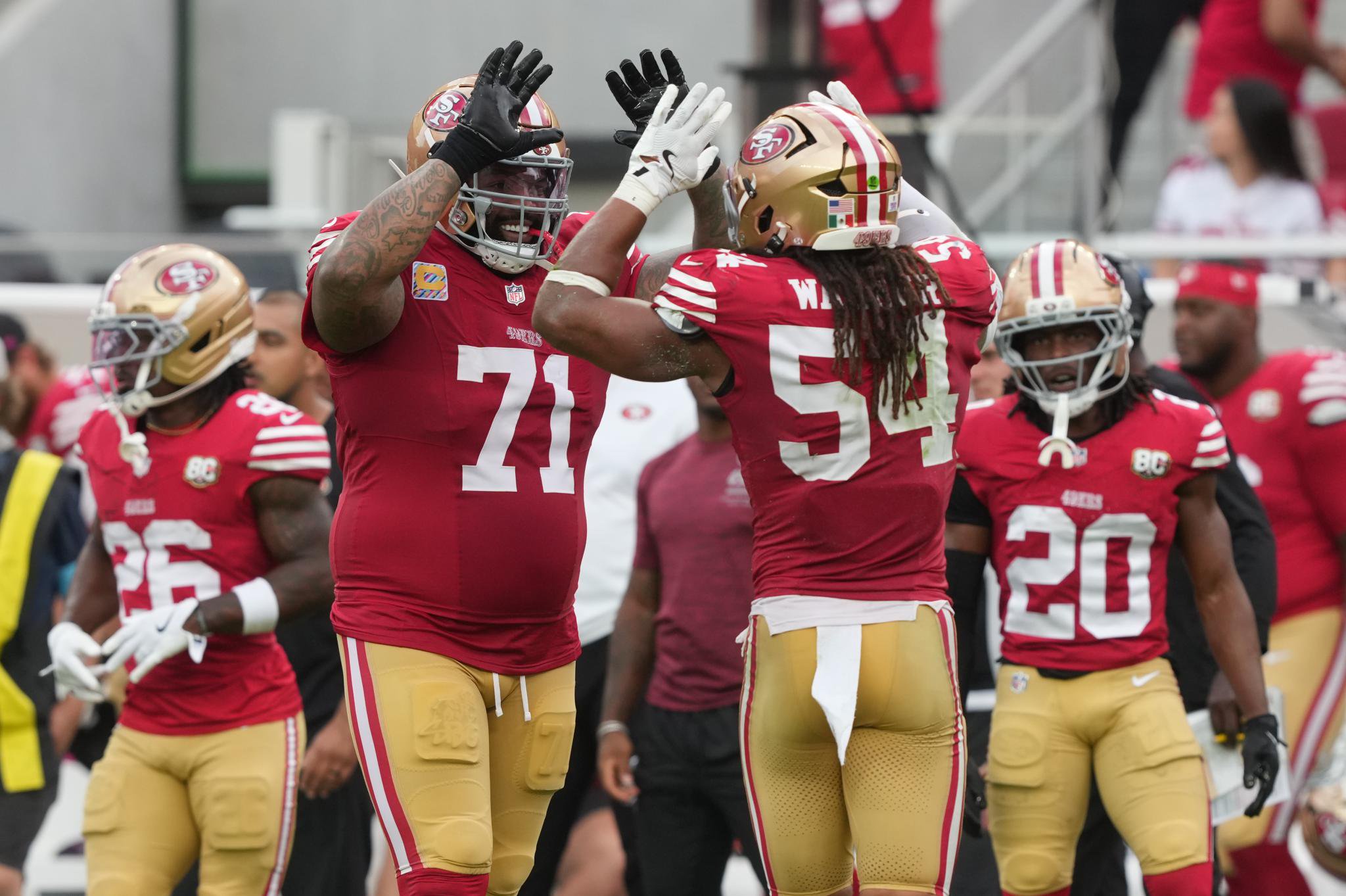 San Francisco 49ers offensive tackle Trent Williams and linebacker Fred Warner high five during a game against the Denver Broncos.