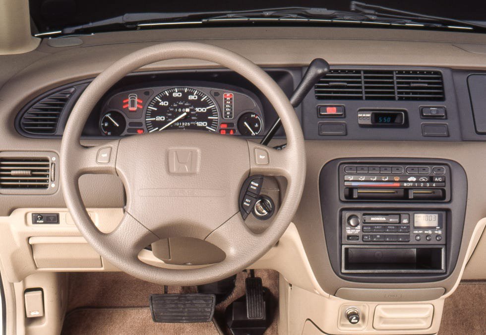 Interior view of a Honda vehicle's dashboard, featuring steering wheel, gauges, and audio system.