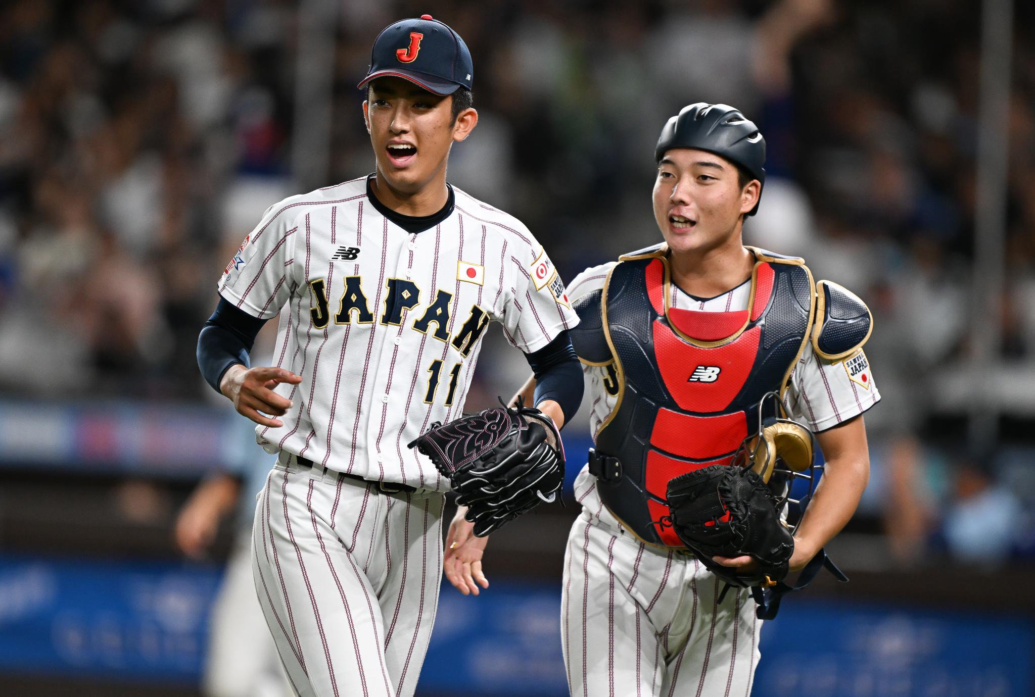 Shoki Oda #11 of Team Japan interacts with Ritora Yamada #2 of Team Japan on the field.