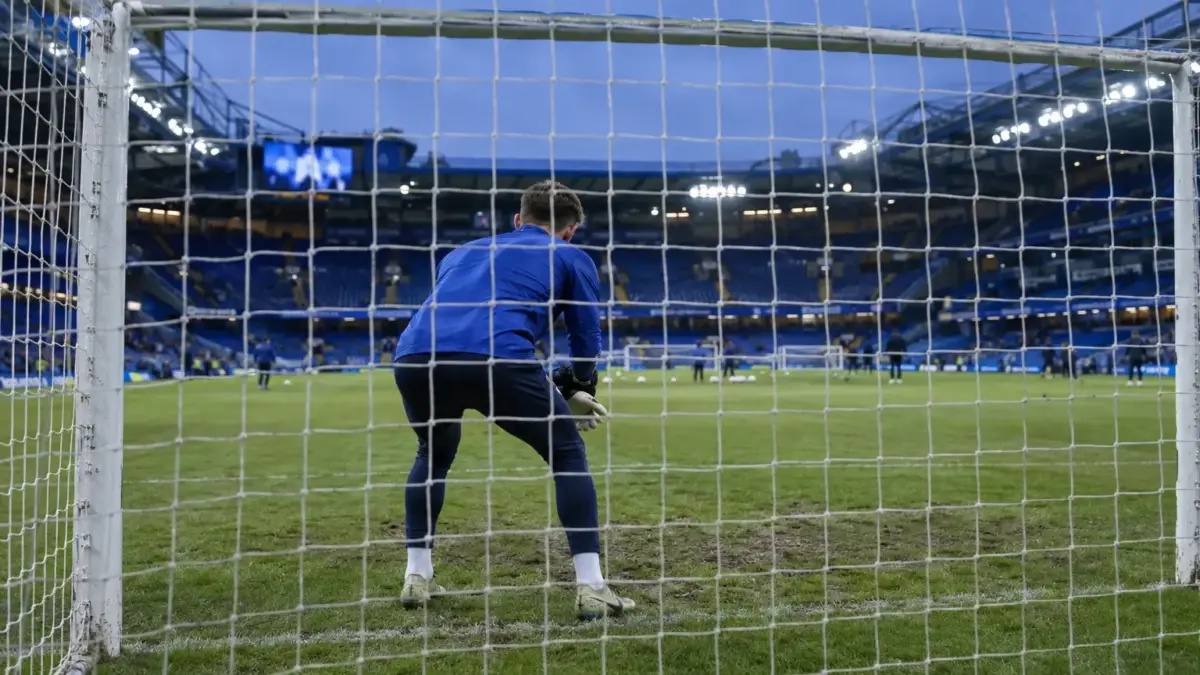 Young goalkeeper warming up inside the goal at Stamford Bridge before a match