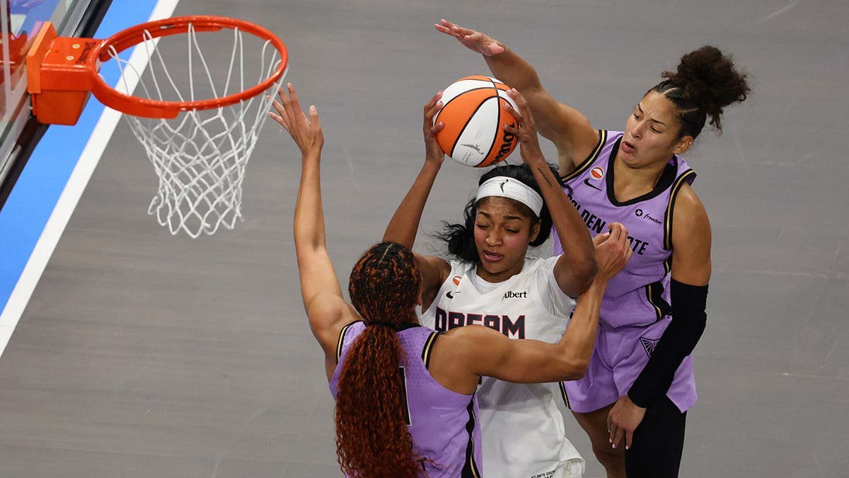 Angel Reese of the Atlanta Dream shoots against Kiah Stokes and Veronica Burton of the Golden State Valkyries.