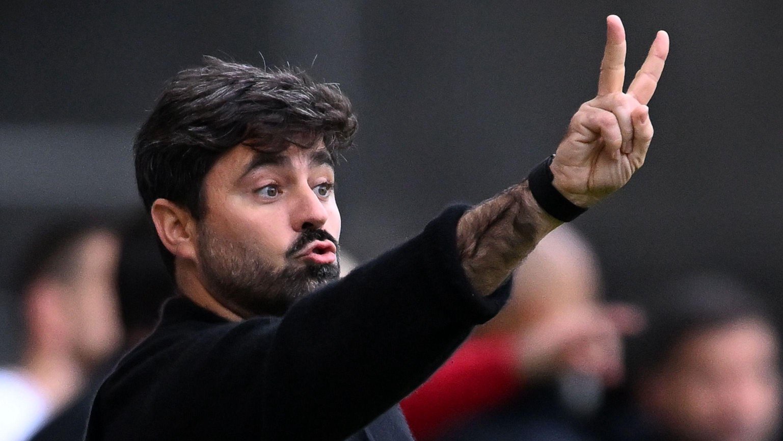 Vitor Matos in black holds up two fingers as he gives instructions from the touchline during Swansea's defeat to West Ham 