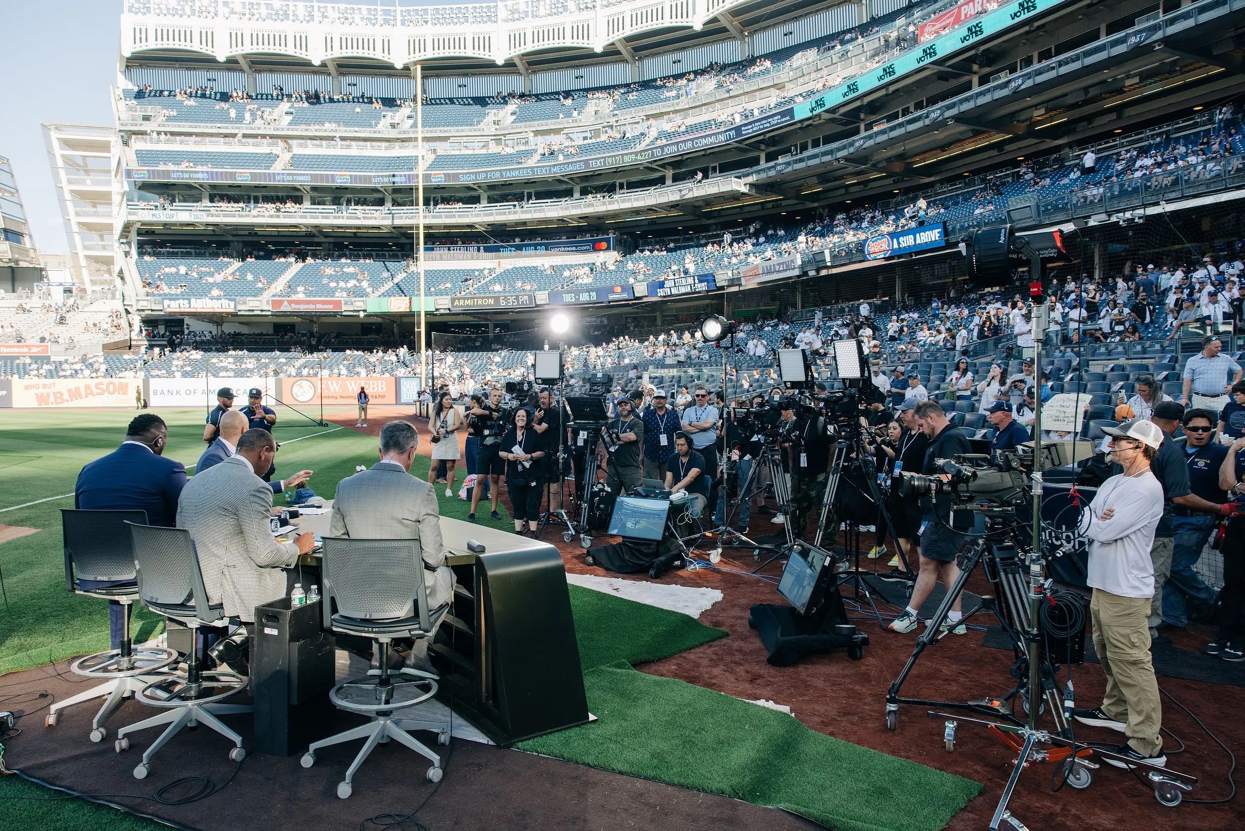 The MLB on Fox crew prepares at their desk, while cameras set up for the live show.