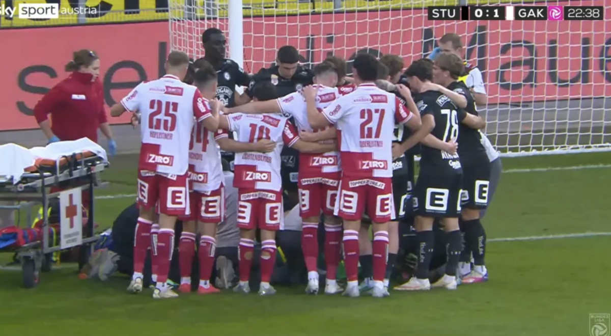 Players from both teams huddled around injured goalkeeper Daniil Khudyakov