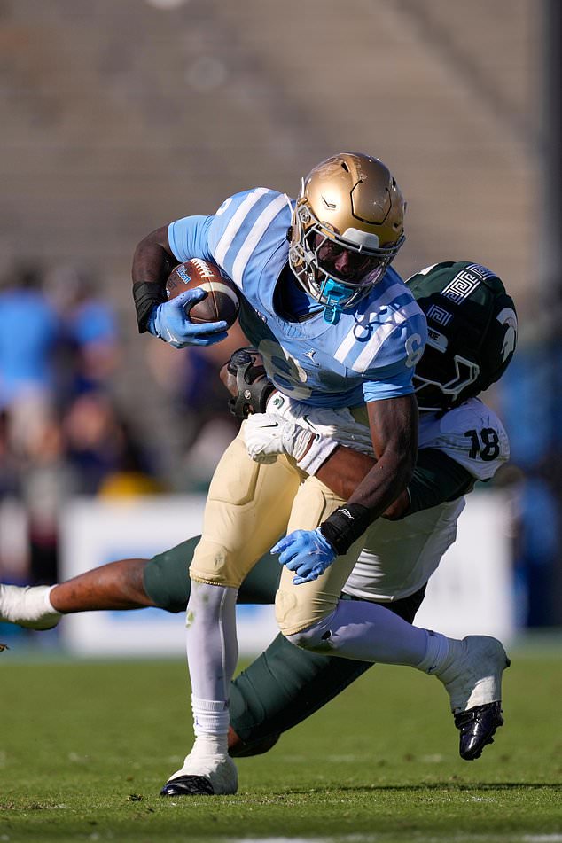 UCLA running back Anthony Woods, left, is dragged down by Michigan State linebacker Dion Crawford during the second half of an NCAA college football game, Saturday, Oct. 24, 2026, in Pasadena, Calif. (AP Photo/Mark J. Terrill)