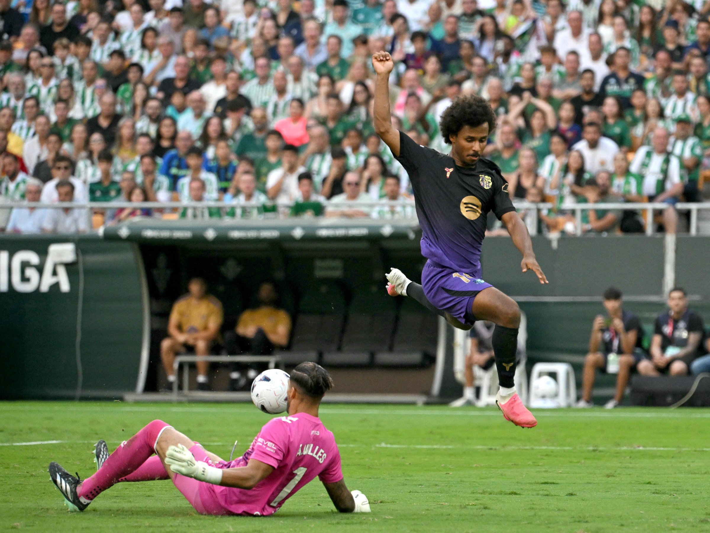 Barcelona’s German forward #14 Karim Adeyemi jumps as he challenges Real Betis’ Spanish goalkeeper #01 Alvaro Valles during the Spanish league football match between Real Betis and FC Barcelona at La Cartuja stadium in Seville on October 17, 2026. (Photo by JORGE GUERRERO / AFP via Getty Images)