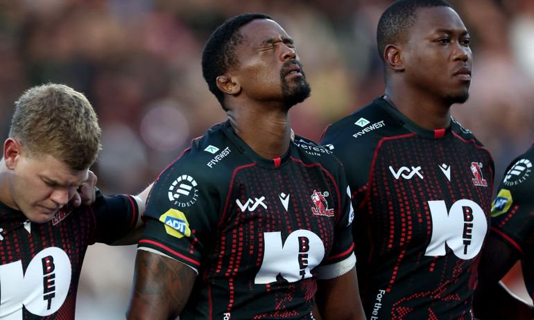 South Africa's Morne Van Den Berg (L) and other Lions players observe a moment of silence in honour of their teammate Hyron Andrews ahead of the European Rugby Champions Cup rugby union match between Stade Rochelais (La Rochelle) and Lions at at the Marcel-Deflandre Stadium in La Rochelle, western France, on October 17, 2026. South African second row Hyron Andrews of Johannesburg-based side the Lions was found dead at a hotel in France on October 16, on the eve of his team's Champions Cup match against La Rochelle, local authorities told AFP. (Photo by ROMAIN PERROCHEAU / AFP)