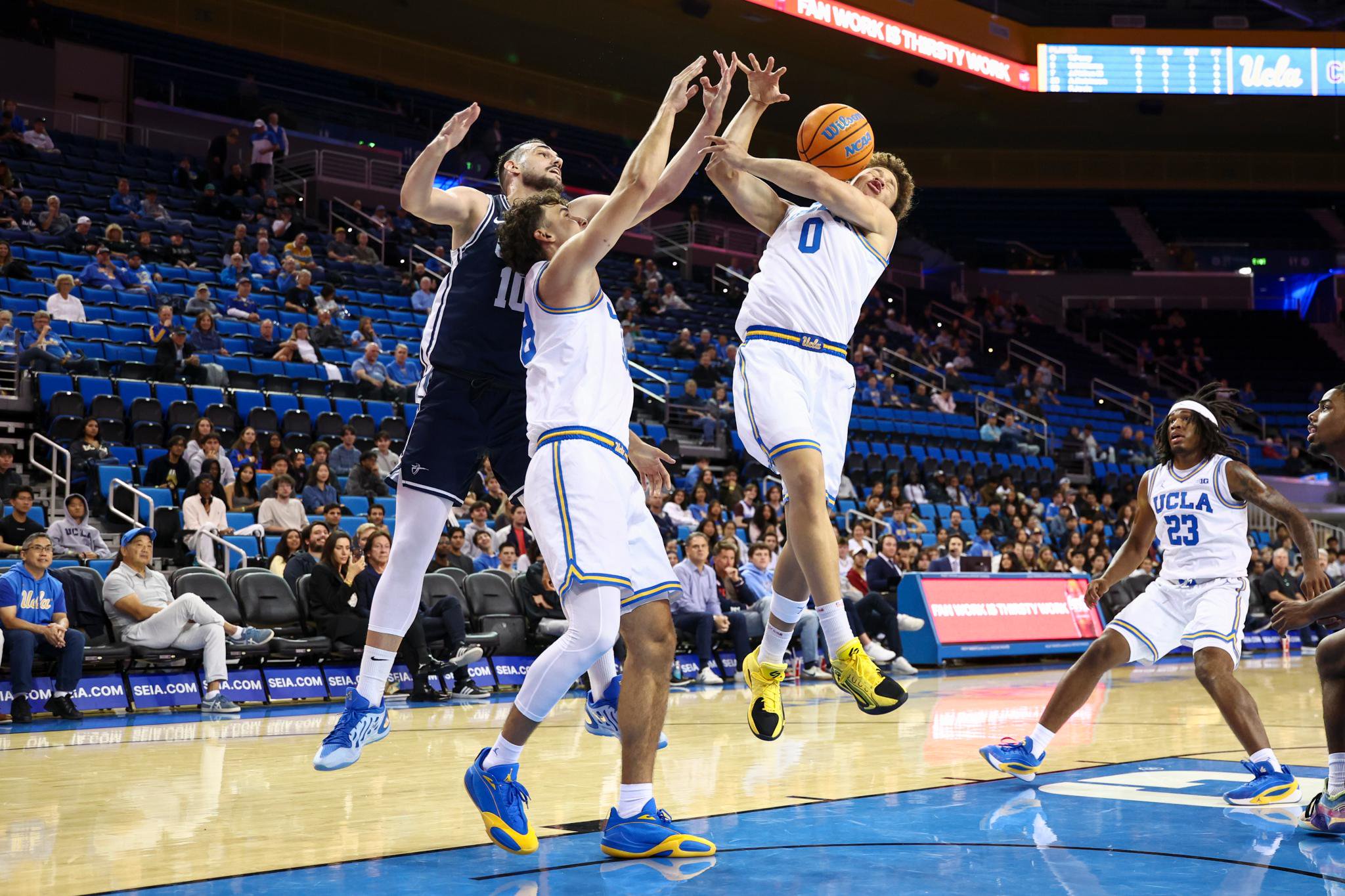 Basketball players battle for a rebound during a game between Cal Baptist and UCLA.