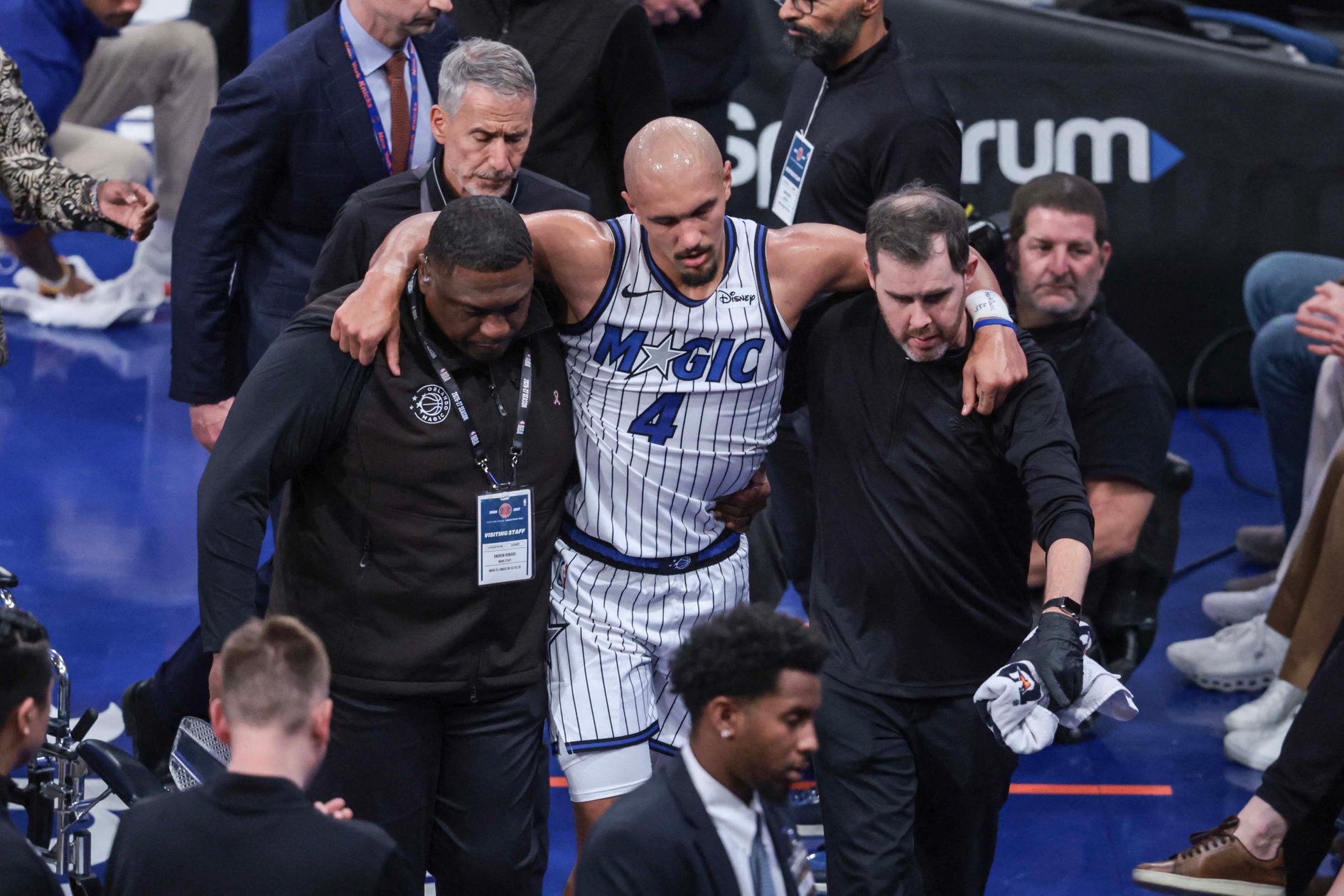 Oct 25, 2026; New York, New York, USA;  Orlando Magic guard Jalen Suggs (4) is helped off the court after an injury in the fourth quarter against the New York Knicks at Madison Square Garden. Mandatory Credit: Wendell Cruz-Imagn Images