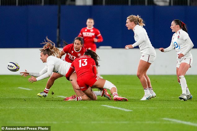 England's Zoe Harrison, left, is tackled by Canada's Florence Symonds (13) during the first half of a Canadian Football League game in Ottawa, Ontario, Friday, Oct. 16, 2026. (Adrian Wyld/The Canadian Press via AP)