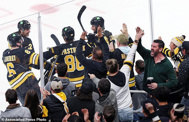 Boston Bruins winger David Pastrnak (88) celebrates with teammates as fans react after he scored a third-period goal during an NHL hockey game against the San Jose Sharks, Saturday, Oct. 24, 2026, in Boston. (AP Photo/Jim Davis)