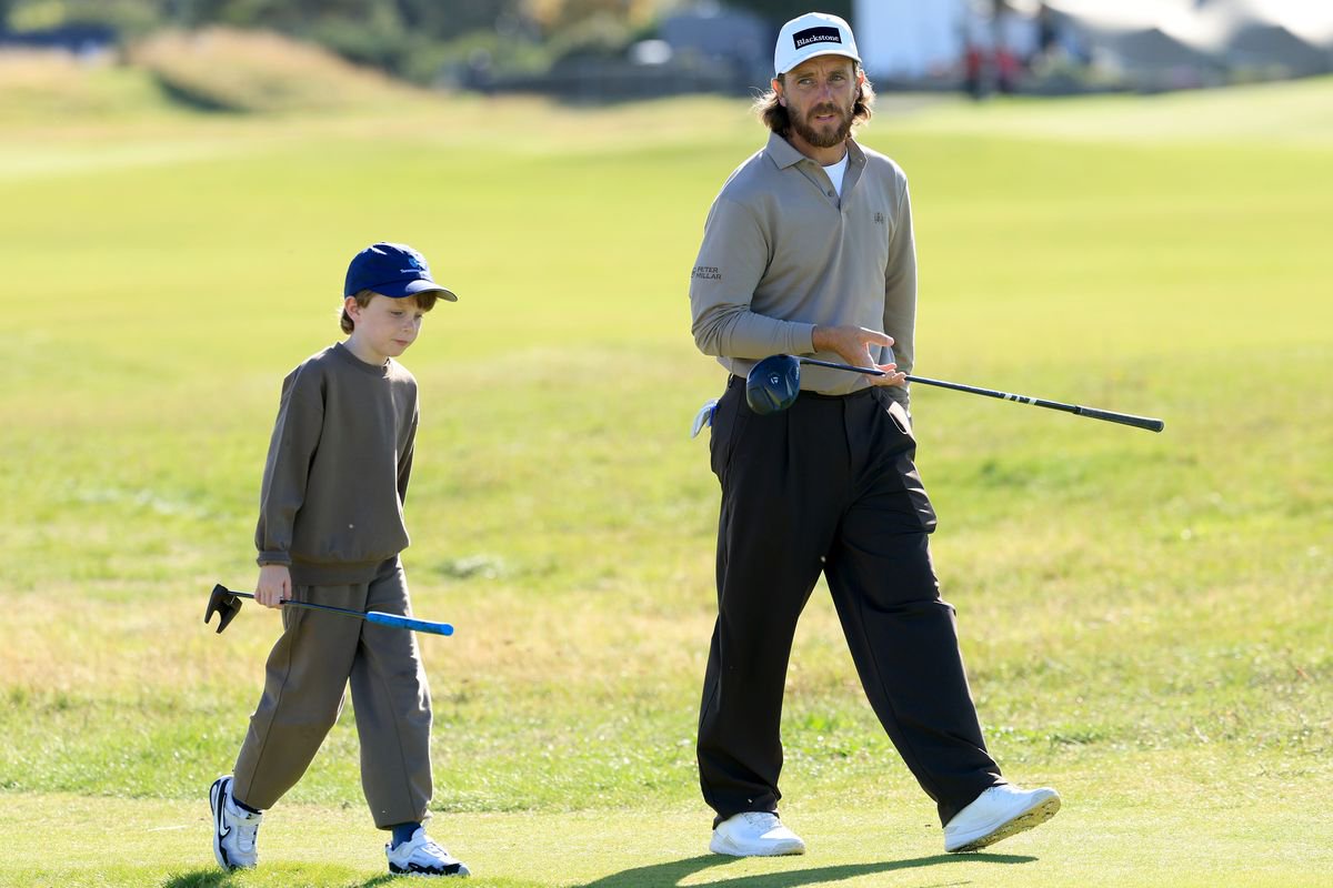 Tommy Fleetwood walks with son, Frankie, during a practice round at St Andrews