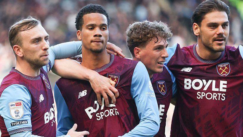 Divine Mukasa (second left) is embraced by his West Ham team-mates after scoring the only goal in their win at leaders Swansea City