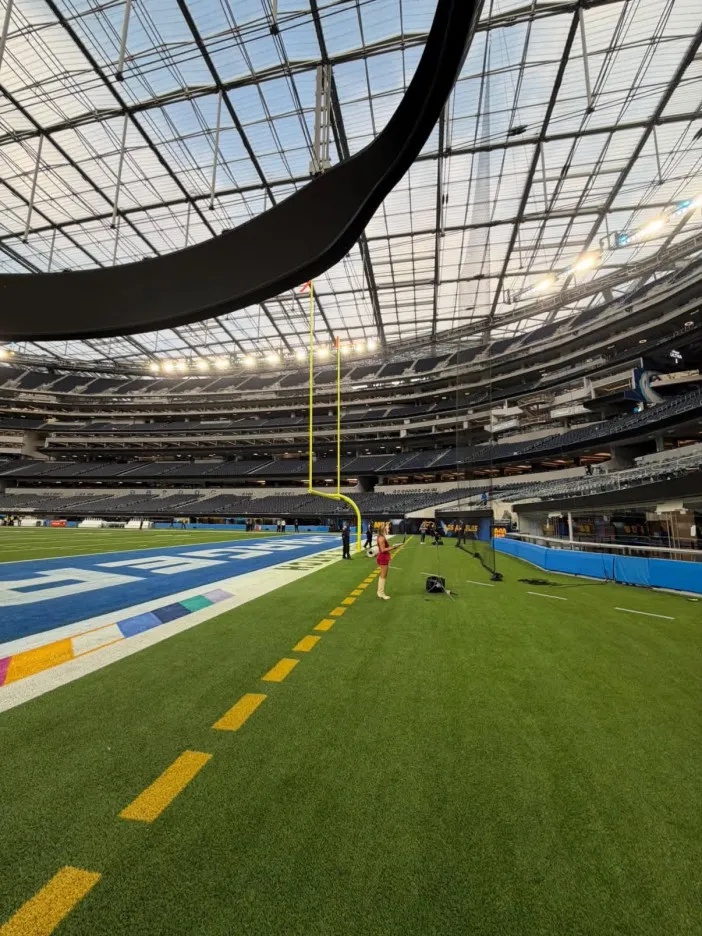 Interior view of an empty modern American football stadium with a transparent roof.