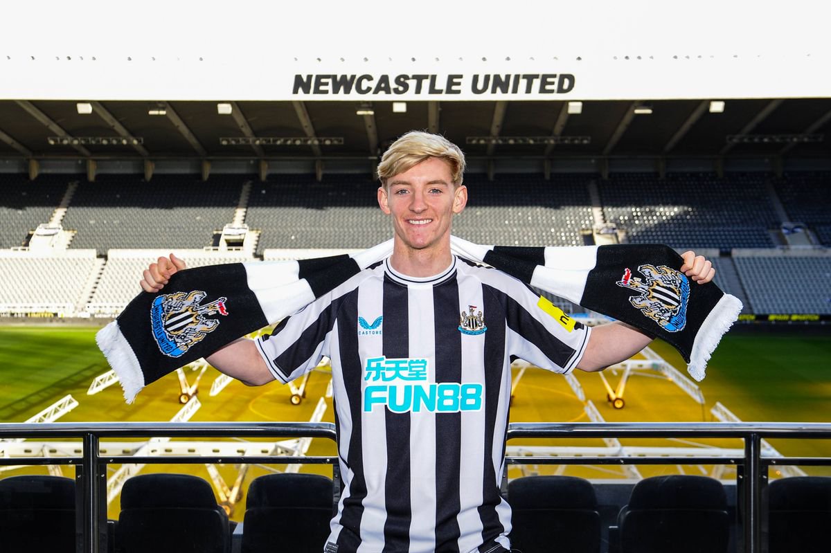 Anthony Gordon poses for photos with a scarf after signing at St.James' Park
