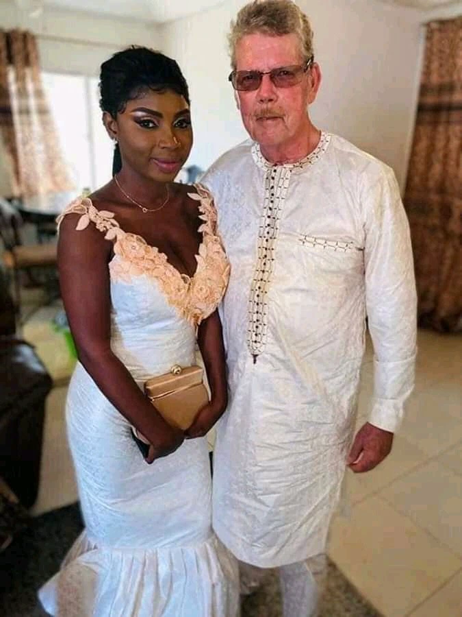 See Photos of a 70-year-old white man and his 22-year-old black wife celebrating 2 years wedding anniversary.