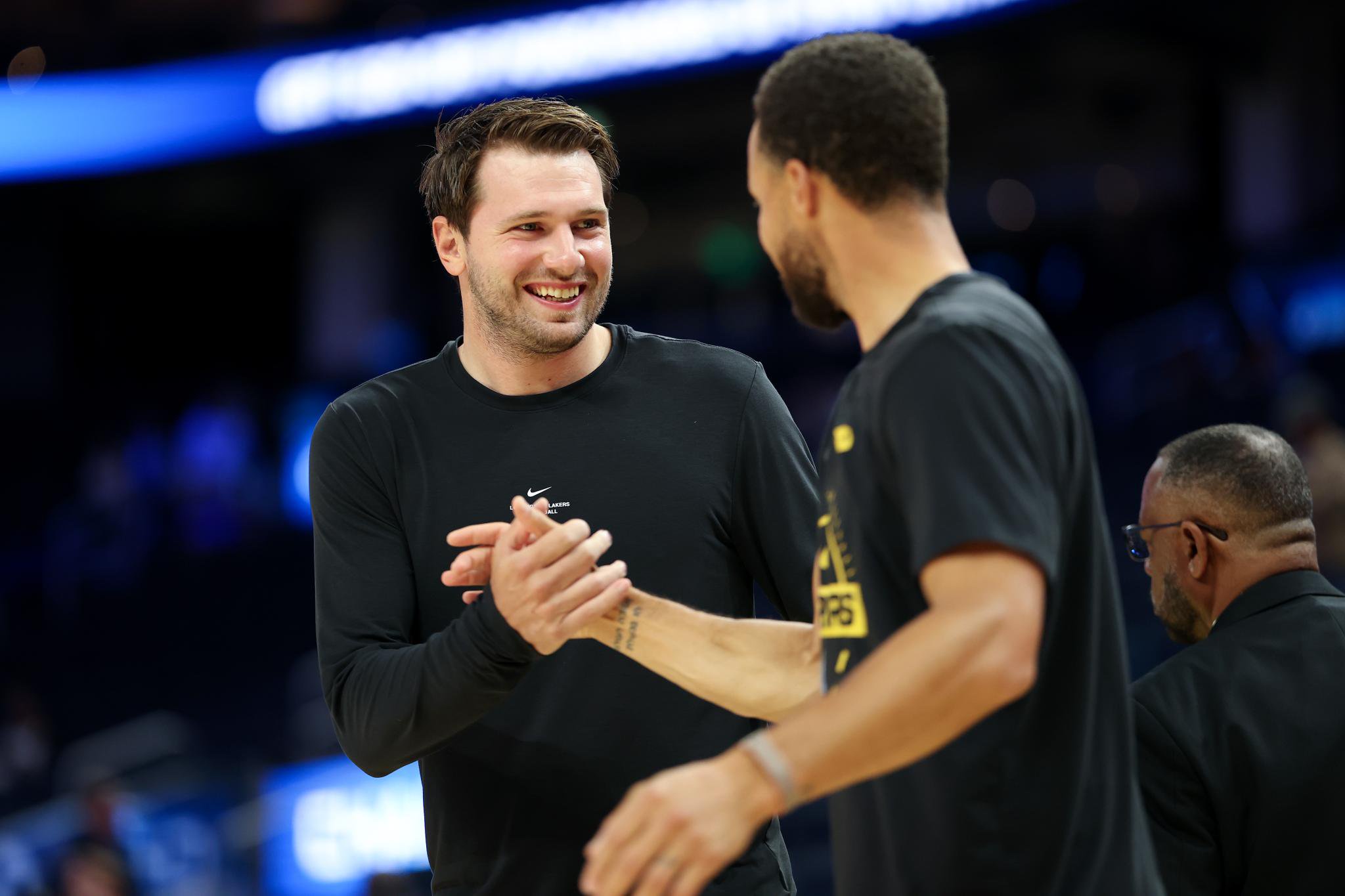Los Angeles Lakers guard Luka Doncic shakes hands with Golden State Warriors guard Stephen Curry before a game.