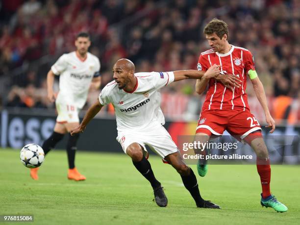 Bayern munichs thomas mueller and sevillas steven nzonzi battle for the ball during the uefa
