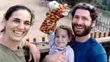 Maya Roman A photo of Yarden Roman-Gat, her husband Alon and three-year-old daughter Gefen, smiling as the child holds up a giraffe glove puppet