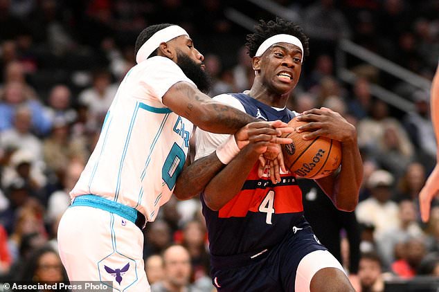 Washington Wizards forward AJ Dybantsa (4) goes to the basket against Charlotte Hornets forward Royce O'Neale, left, during the first half of an NBA Cup basketball game, Friday, Oct. 30, 2026, in Washington. (AP Photo/Nick Wass)