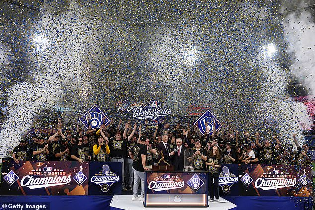The Brewers are given the Commissioner's Trophy as blue and gold confetti falls around them