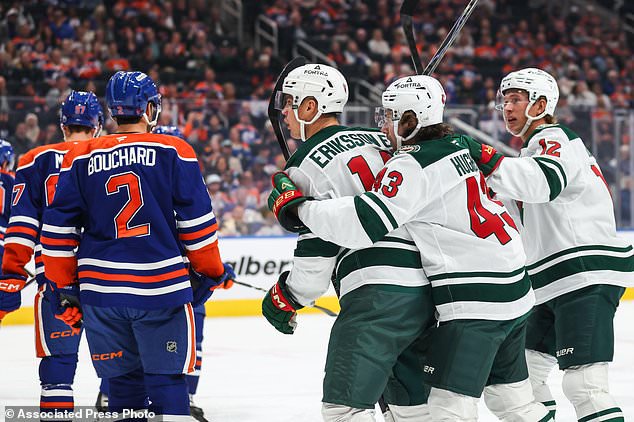 Minnesota Wild's Joel Eriksson Ek (14), third form right, Quinn Hughes (43) and Matt Boldy (12) celebrate a goal against the Edmonton Oilers during the first period of an NHL hockey game in Edmonton, Alberta, Tuesday, Oct. 20, 2026. (Codie McLachlan/The Canadian Press via AP)