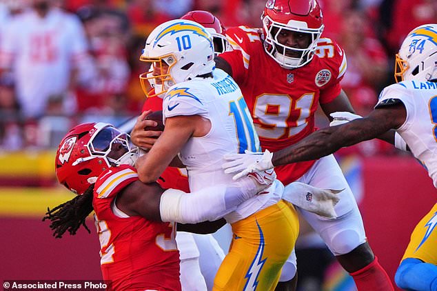 Los Angeles Chargers quarterback Justin Herbert (10) is tackled by Kansas City Chiefs linebacker Nick Bolton, left, as Herbert runs the ball during the first half of an NFL football game in Kansas City, Mo., Sunday, Oct. 18, 2026. (AP Photo/Charlie Riedel)