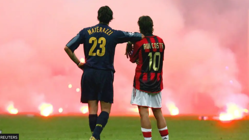 Inter's Materazzi leans on Milan player Rui Costa's shoulder