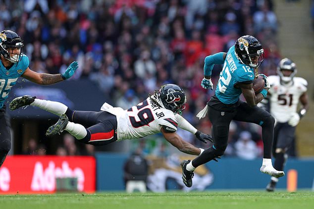 Jacksonville Jaguars wide receiver Travis Hunter (12) gets away from Houston Texans safety M.J. Stewart (29) during an NFL football game in London, Sunday, Oct. 18, 2026. (AP Photo/Ian Walton)