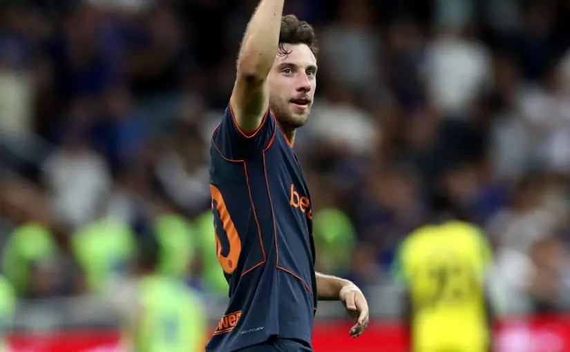 Carlos Augusto of Inter Milan celebrating with his arm raised during a match.