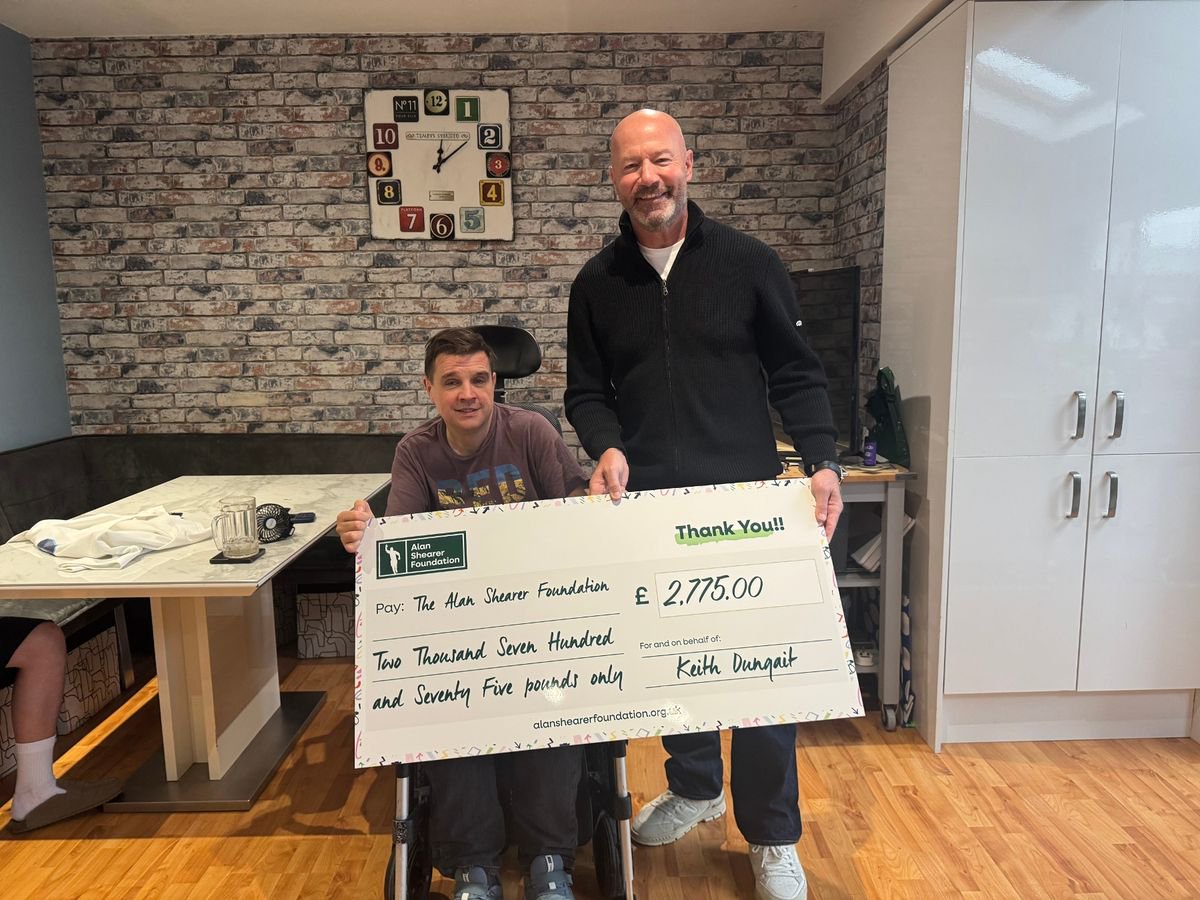 Alan Shearer is presented with a cheque for £2,775 by Keith Dungait at his home in Morpeth