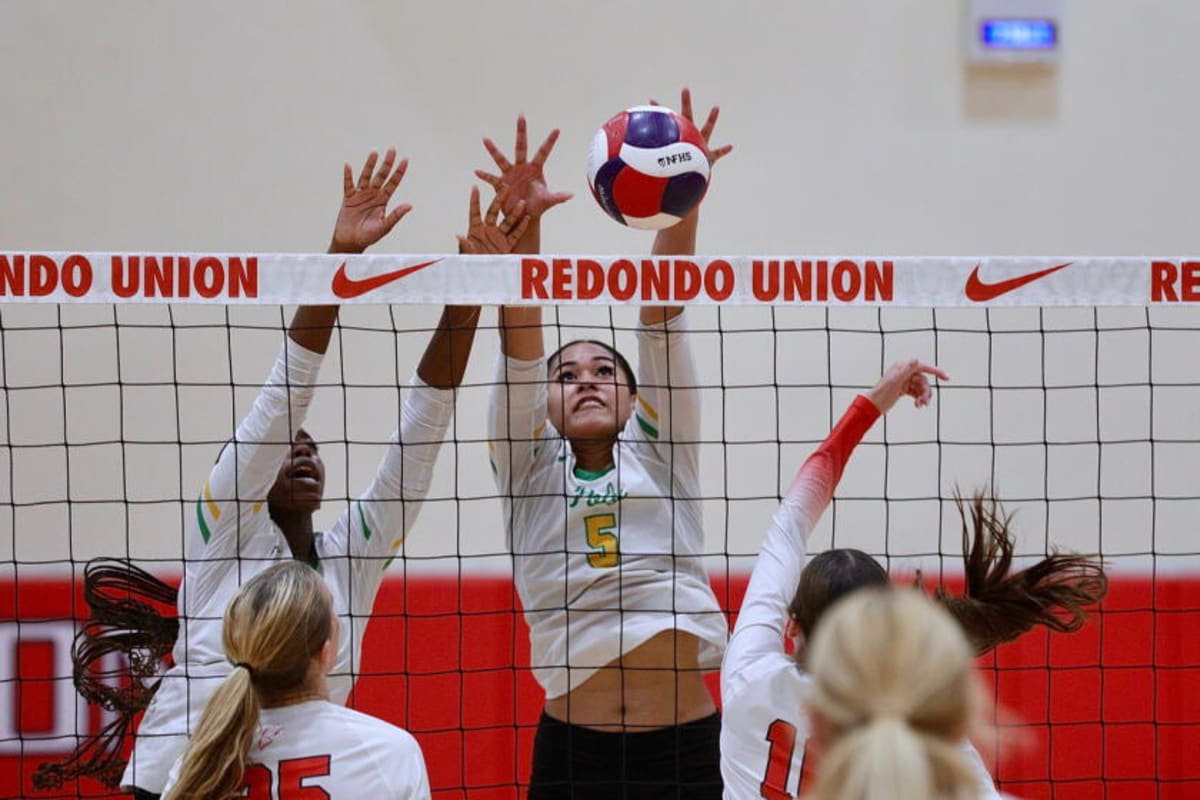 Long Beach Poly High senior McKennah Iamaleava (center) elevates for a block against Redondo Union.