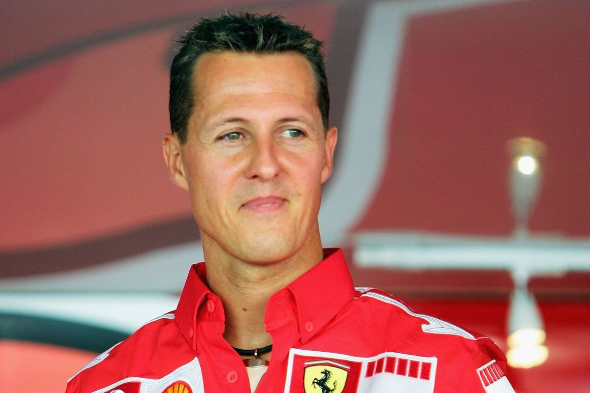 Michael Schumacher poses in a Ferrari race suit