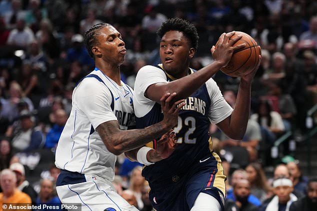 New Orleans Pelicans center Derik Queen (22) drives to the basket as Dallas Mavericks' Tobi Lawal, left, defends during the first half of a preseason NBA basketball game in Dallas, Wednesday, Oct. 14, 2026. (AP Photo/Tony Gutierrez)
