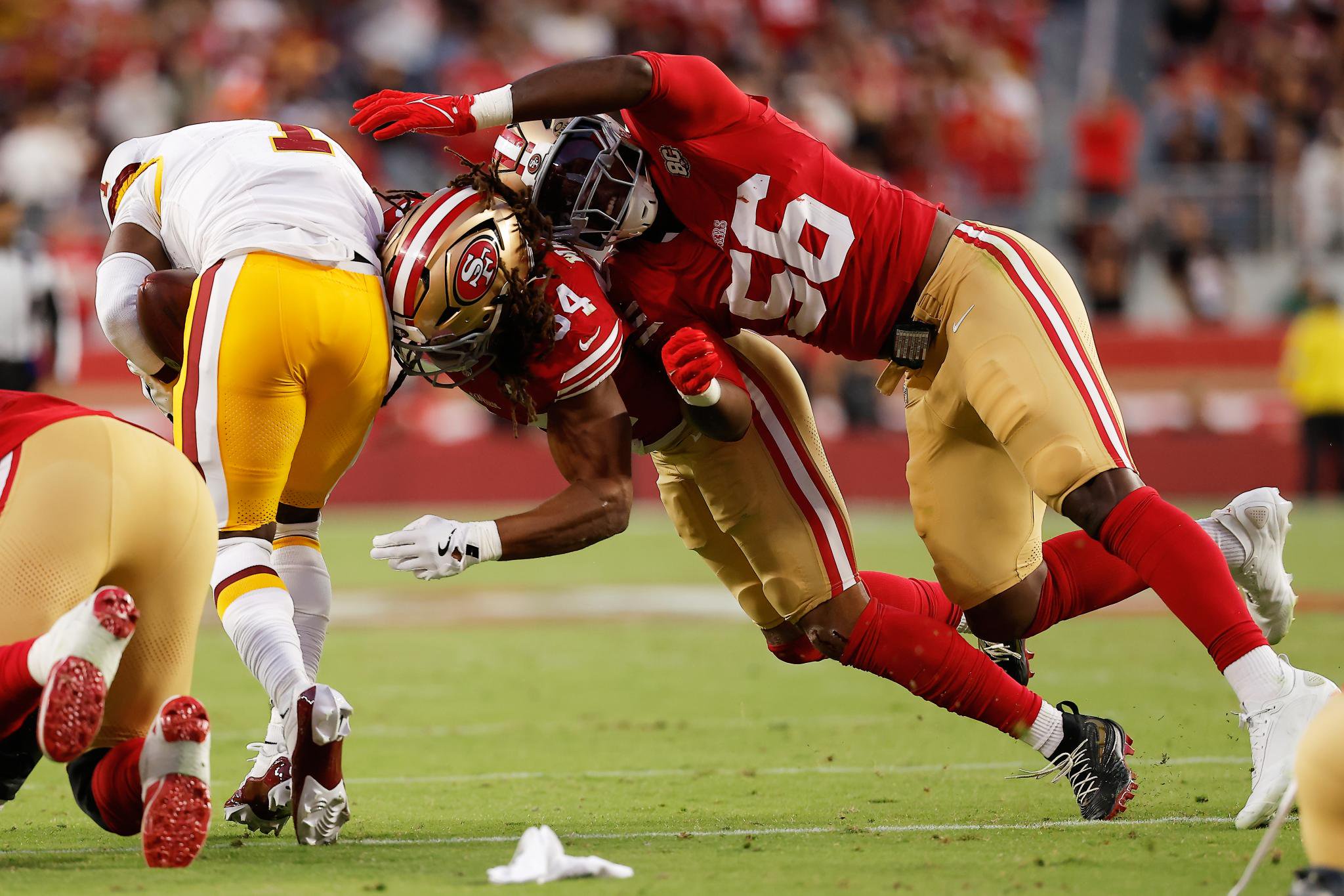 Washington Commanders running back Rachaad White runs against San Francisco 49ers linebacker Fred Warner (54) and defensive end Keion White (56).