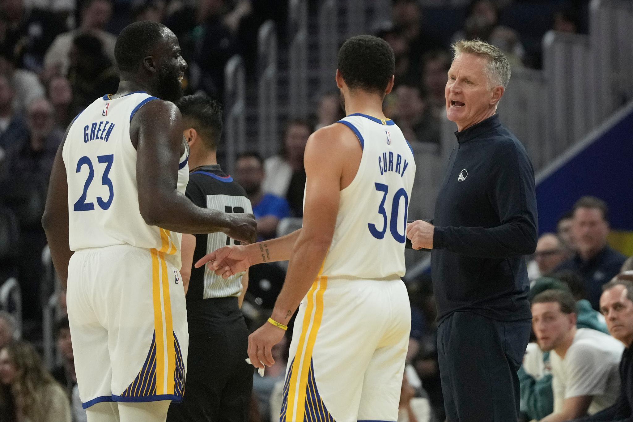 Golden State Warriors head coach Steve Kerr talks with forward Draymond Green and guard Stephen Curry during a game.
