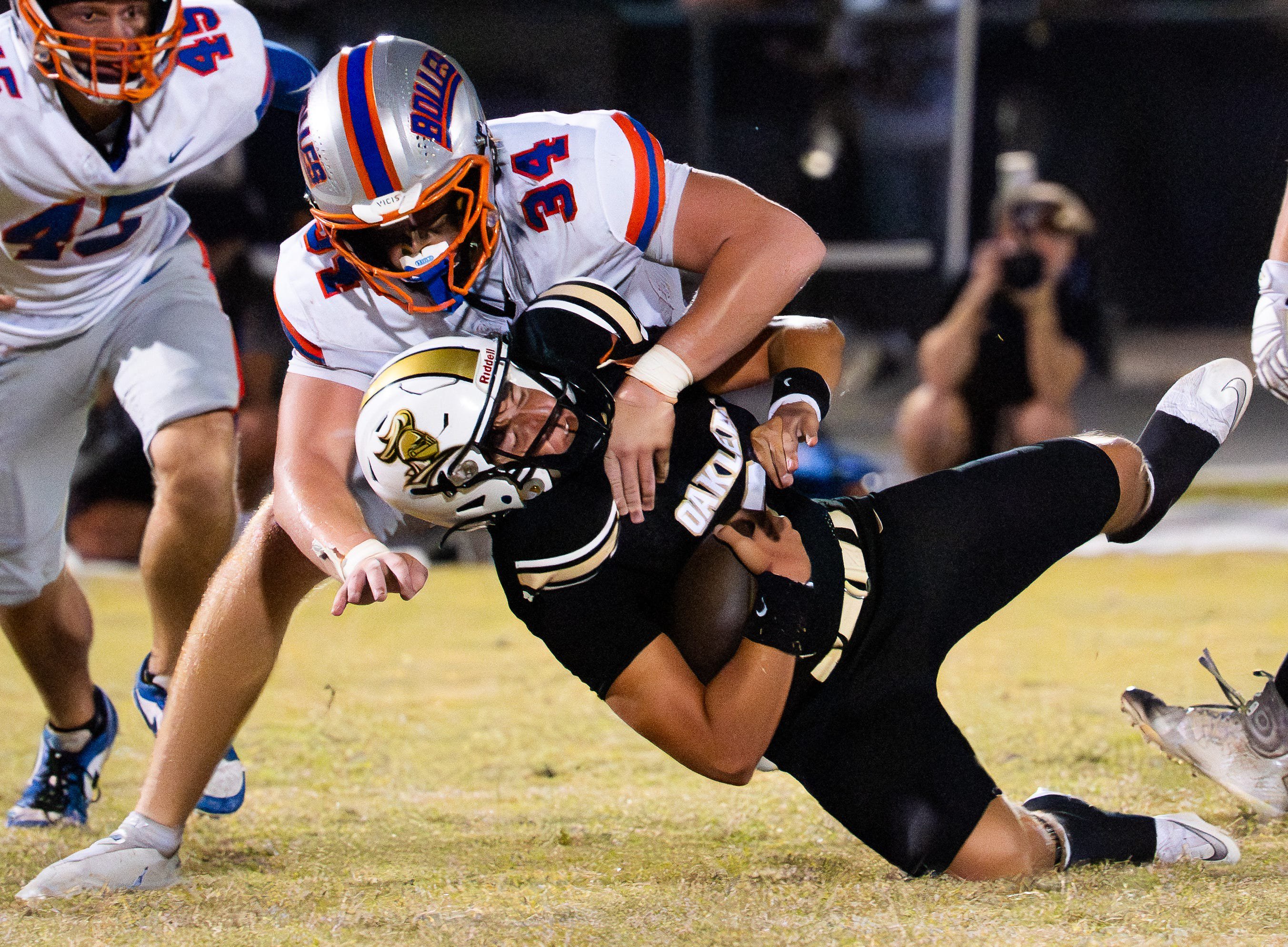 Bolles Bulldogs defensive lineman Asher Ghioto (34) tackles Oakleaf Knights Kashawn Murphy (90)