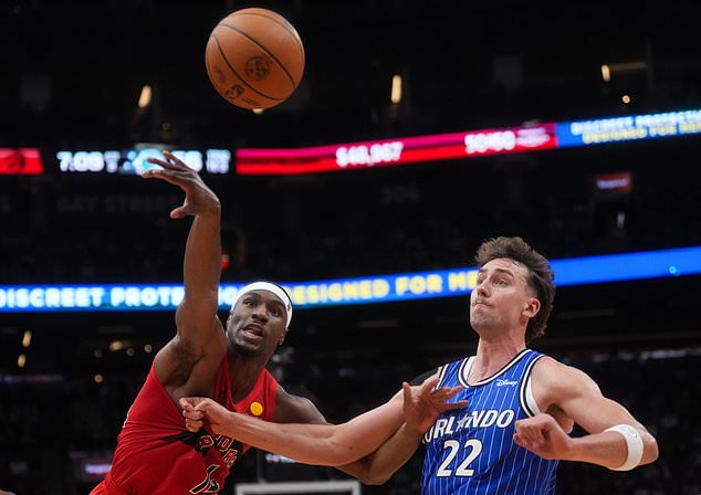 Toronto Raptors' Ja'kobe Walter (14) battles for the ball against Orlando Magic's Franz Wagner (22) during the second half of an NBA basketball game in Toronto, Wednesday, Oct. 28, 2026. (Nathan Denette/The Canadian Press via AP)