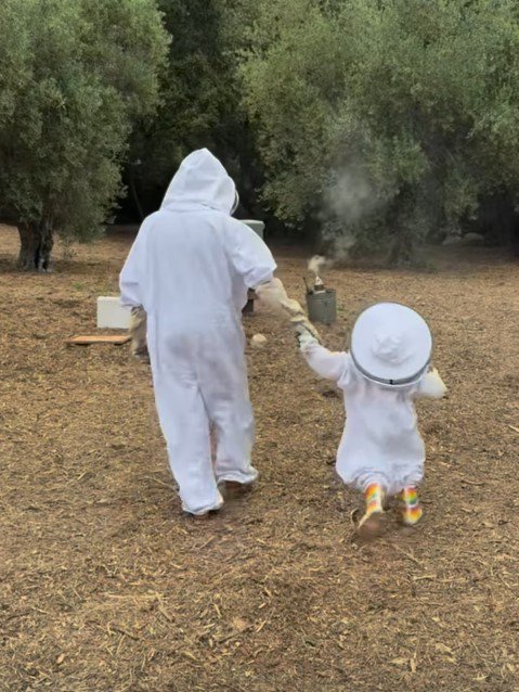 Meghan Markle and Lilibet wearing beekeeping suits.