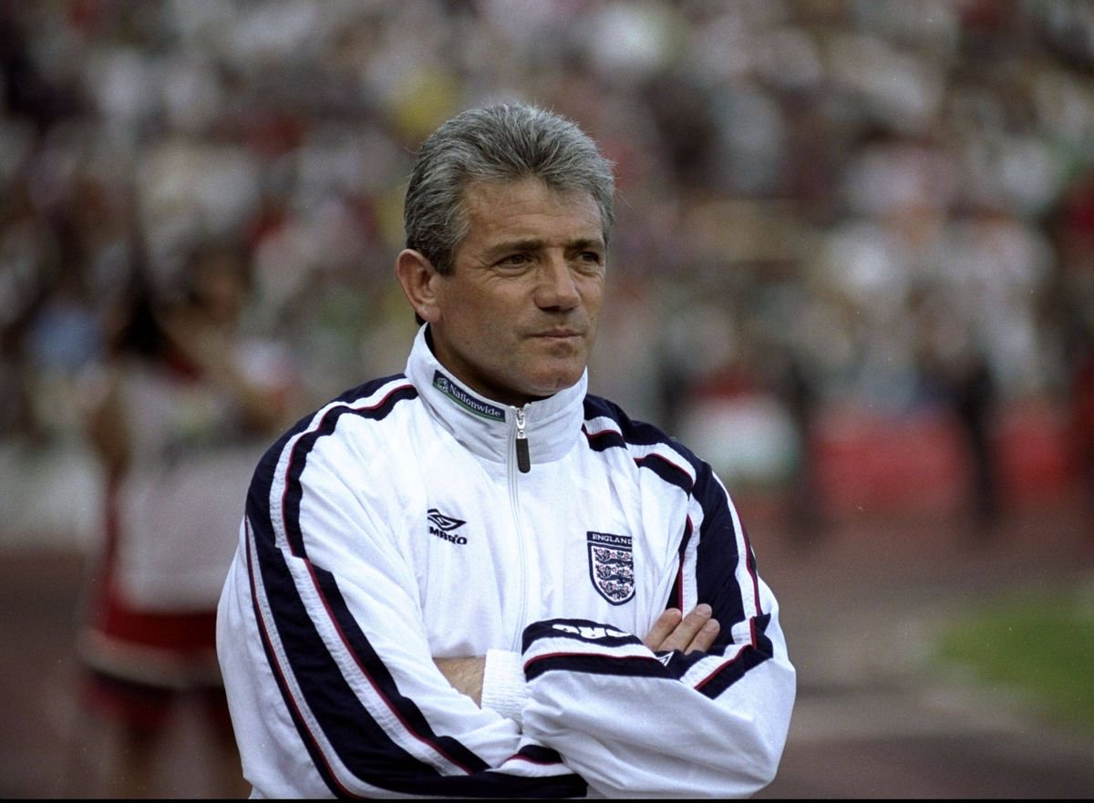 Kevin Keegan standing with arms crossed on pitch